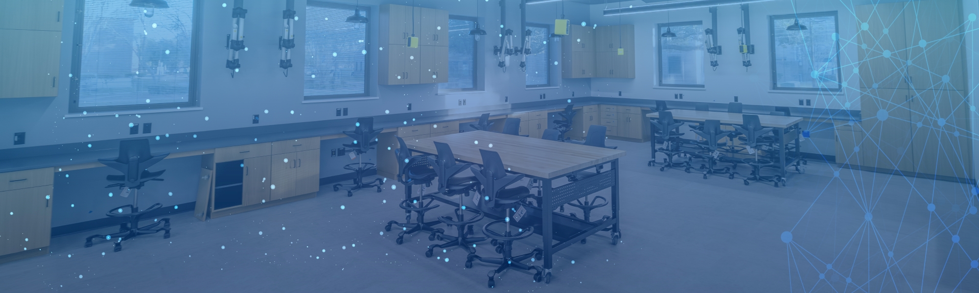 Student workshop lab photo with blue technology graphics.
