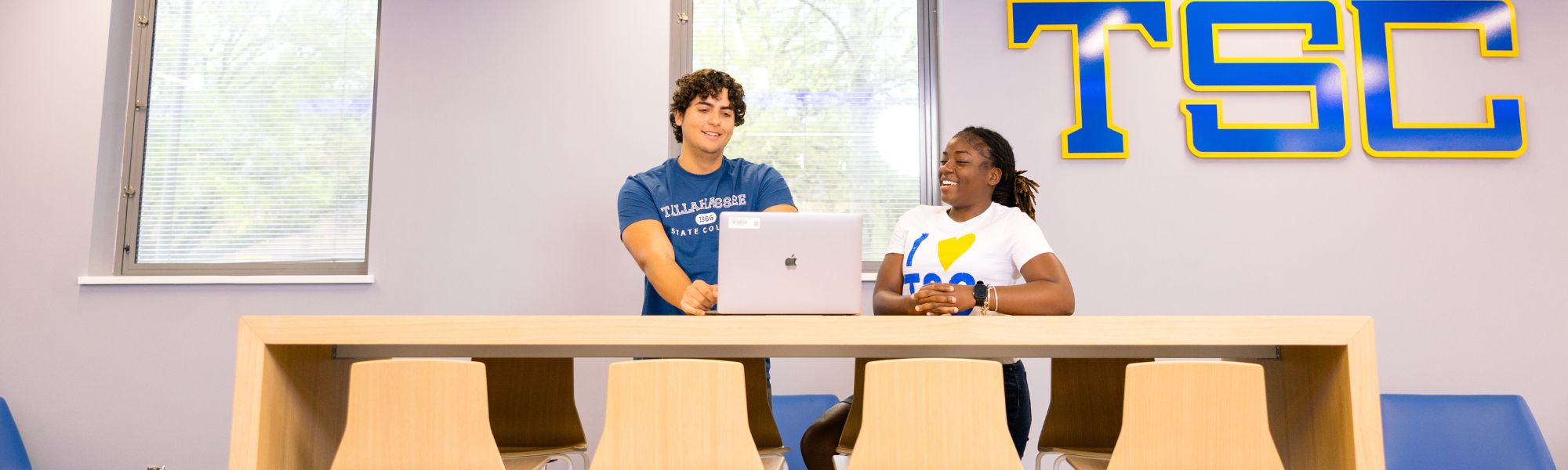 Two students studying together with a laptop.