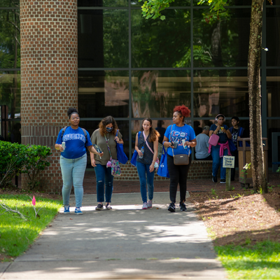 Two female students smiling outside on campus