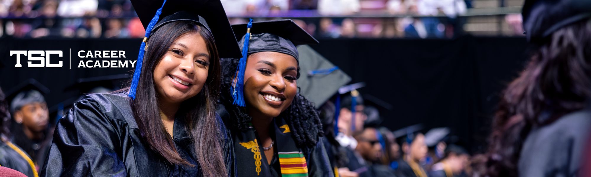 Graduating students smiling at commencement.