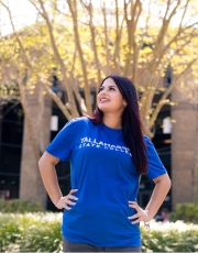 TSC student standing in front of the brick library building and looking upwards.