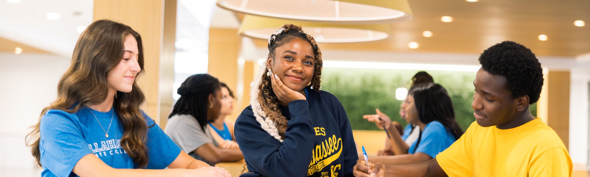 Students smiling and chatting at Student Union tables.