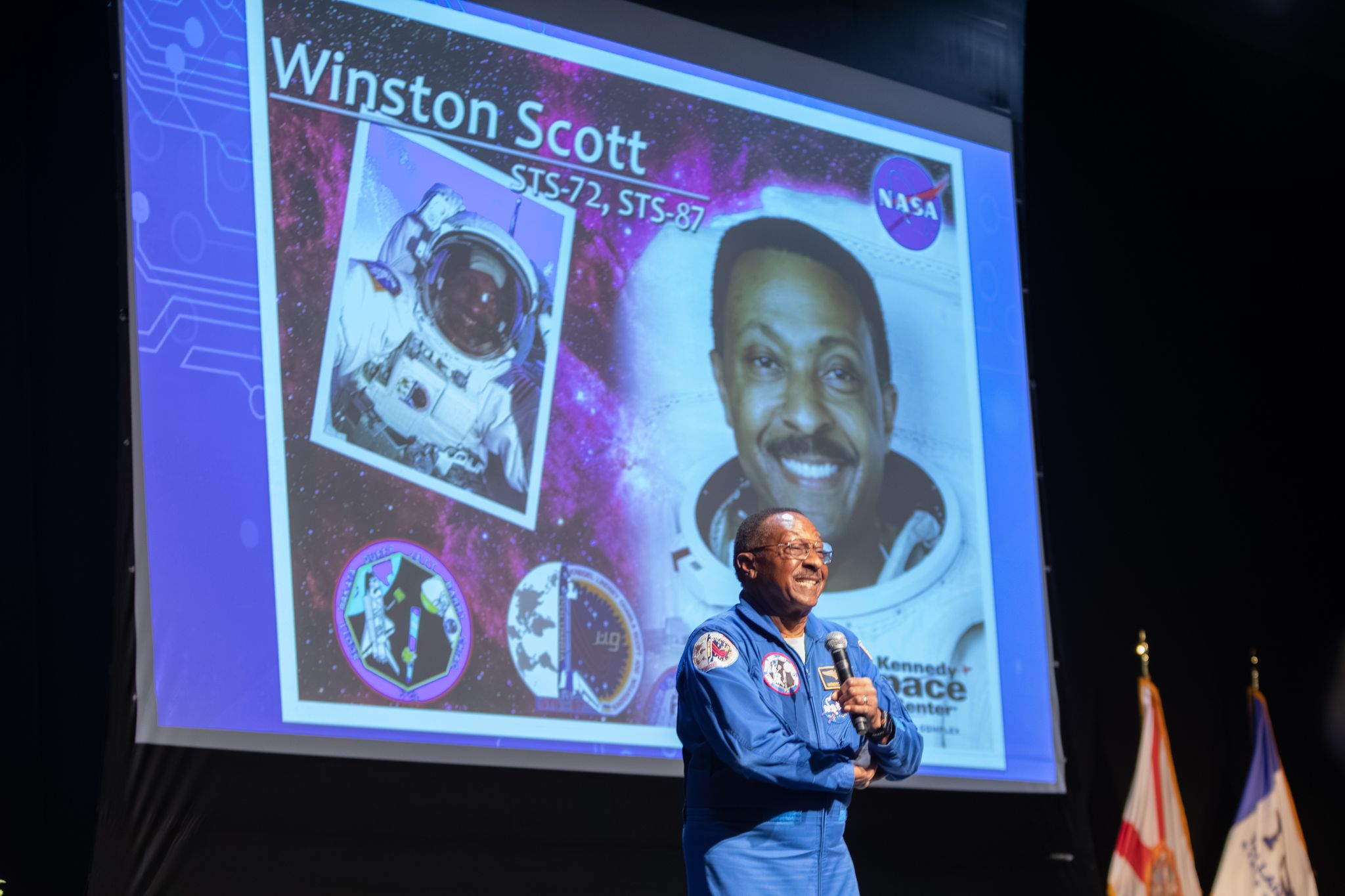 Captain Winston Scott speaking on the auditorium stage.