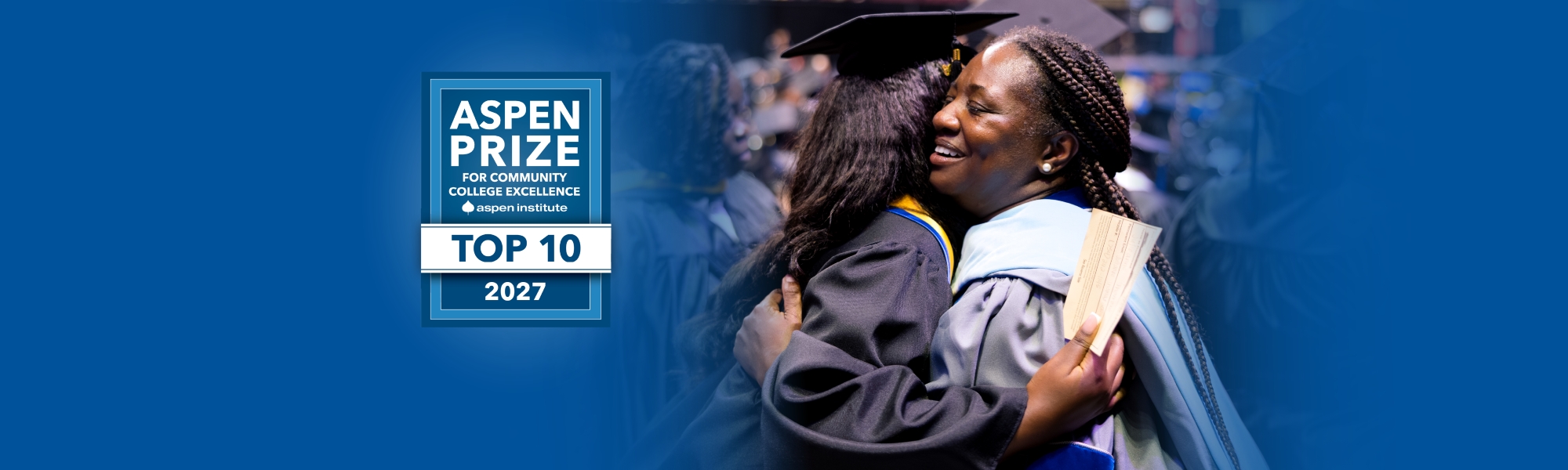 Staff member hugging graduating student with blue background and the Aspen top ten 2027 logo.