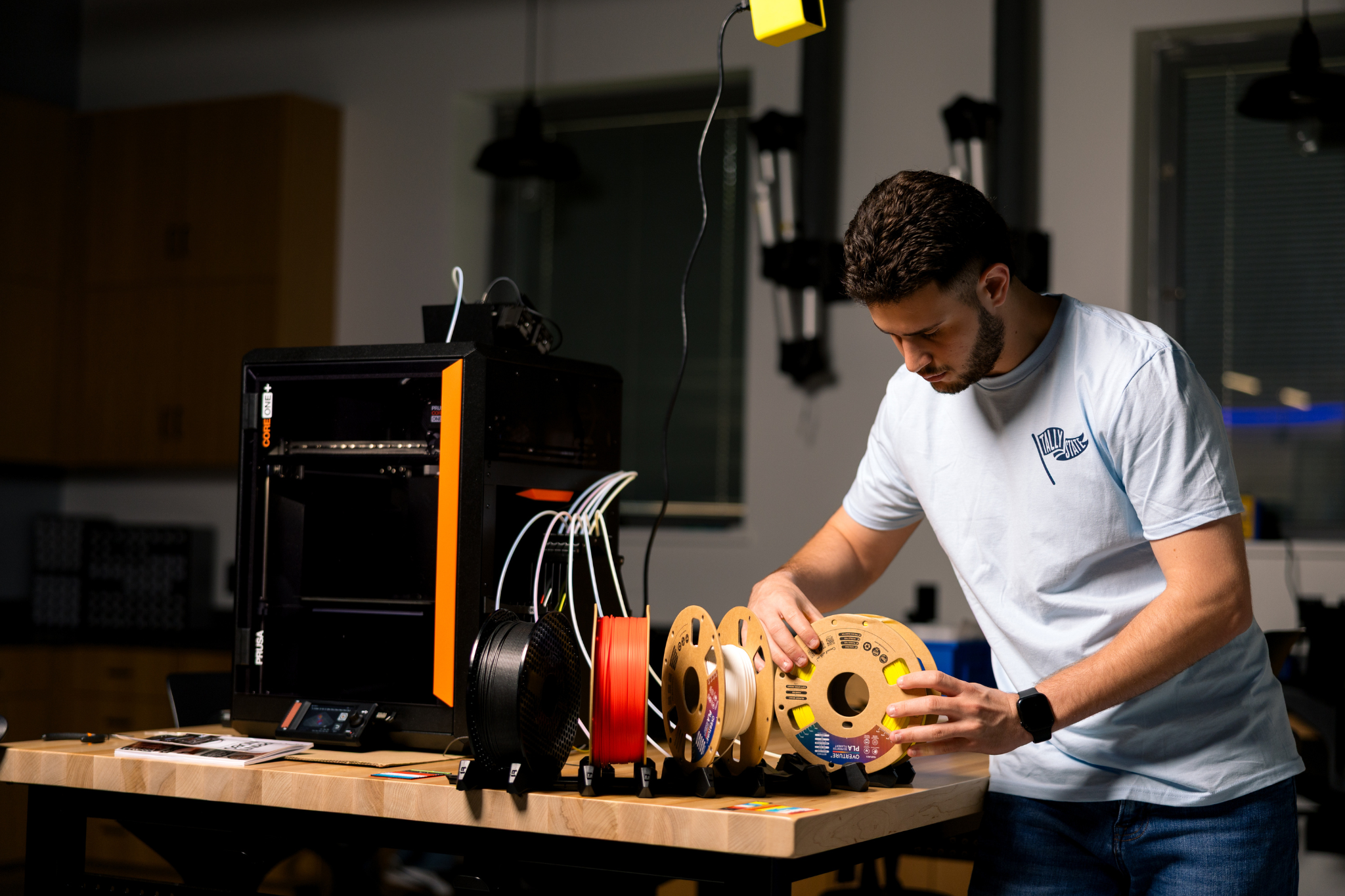 student preparing 3d printer in tsc innovation hub