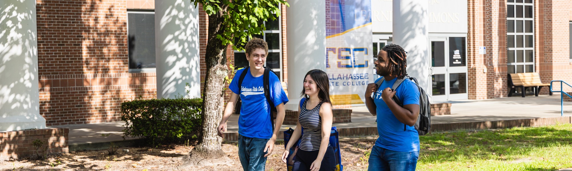 Three students walking past Learning Commons Building.