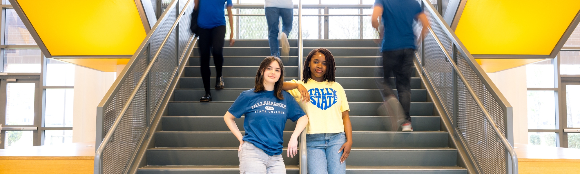 Two TSC students standing at the bottom of the student union staircase.