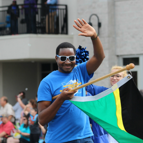 An international student walks in the Springtime Tallahassee parade for TCC's 50th Anniversary