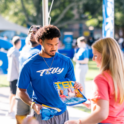 TSC athletic student being handed a TSC bag at convocation.