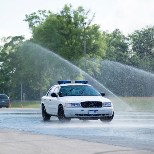 FPSI police training car going through wet road course.